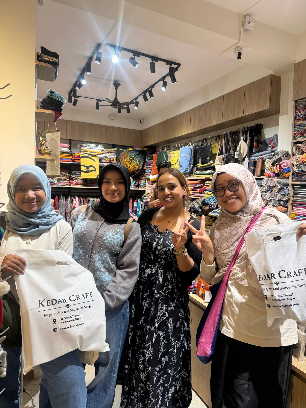 Smiling visitors holding Kedar Craft shopping bags inside the shop
