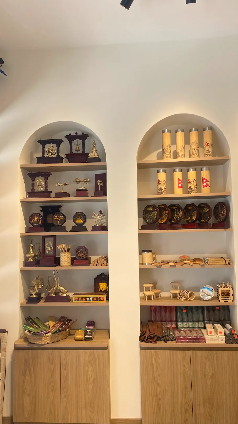 Arched shelves of brass souvenirs, bamboo bottles and wooden gifts